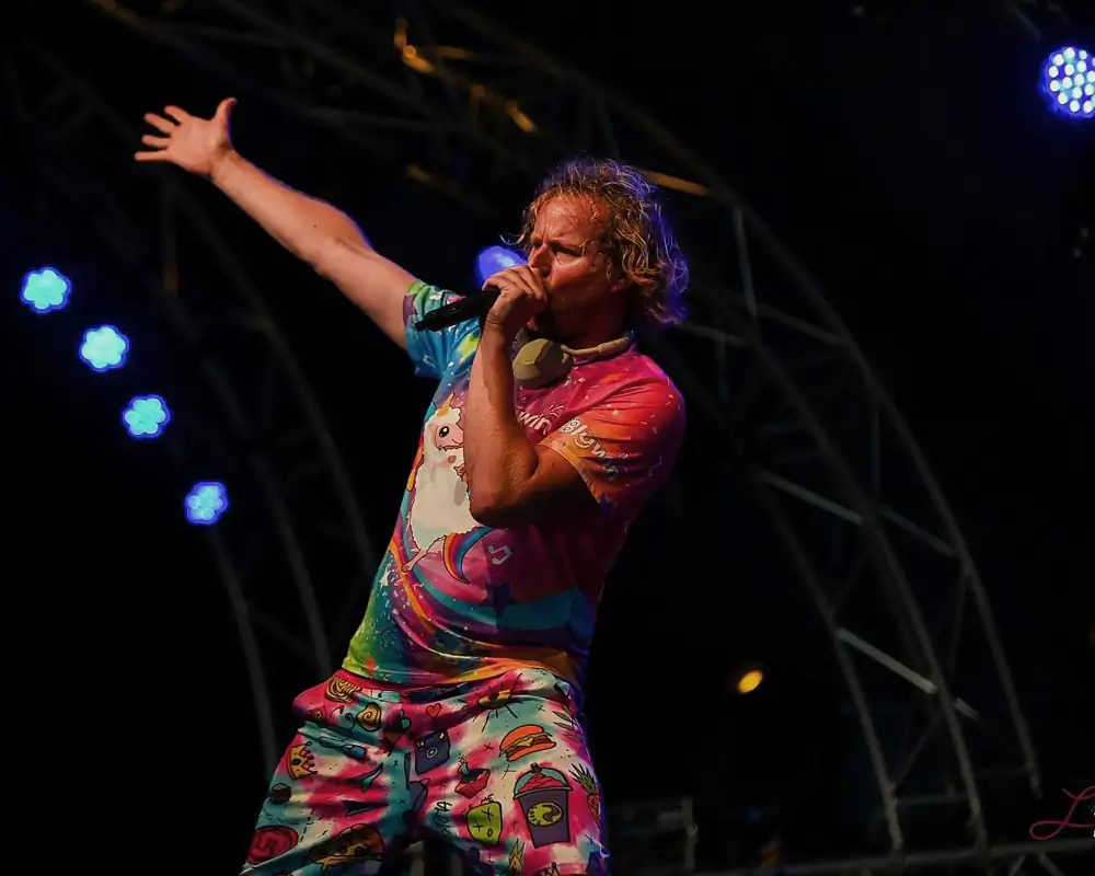 Children's DJ Blijwin® in a colorful outfit on stage during a performance – DJ for children Children's DJ Blijwin® in a colorful outfit on stage during a performance – DJ for children