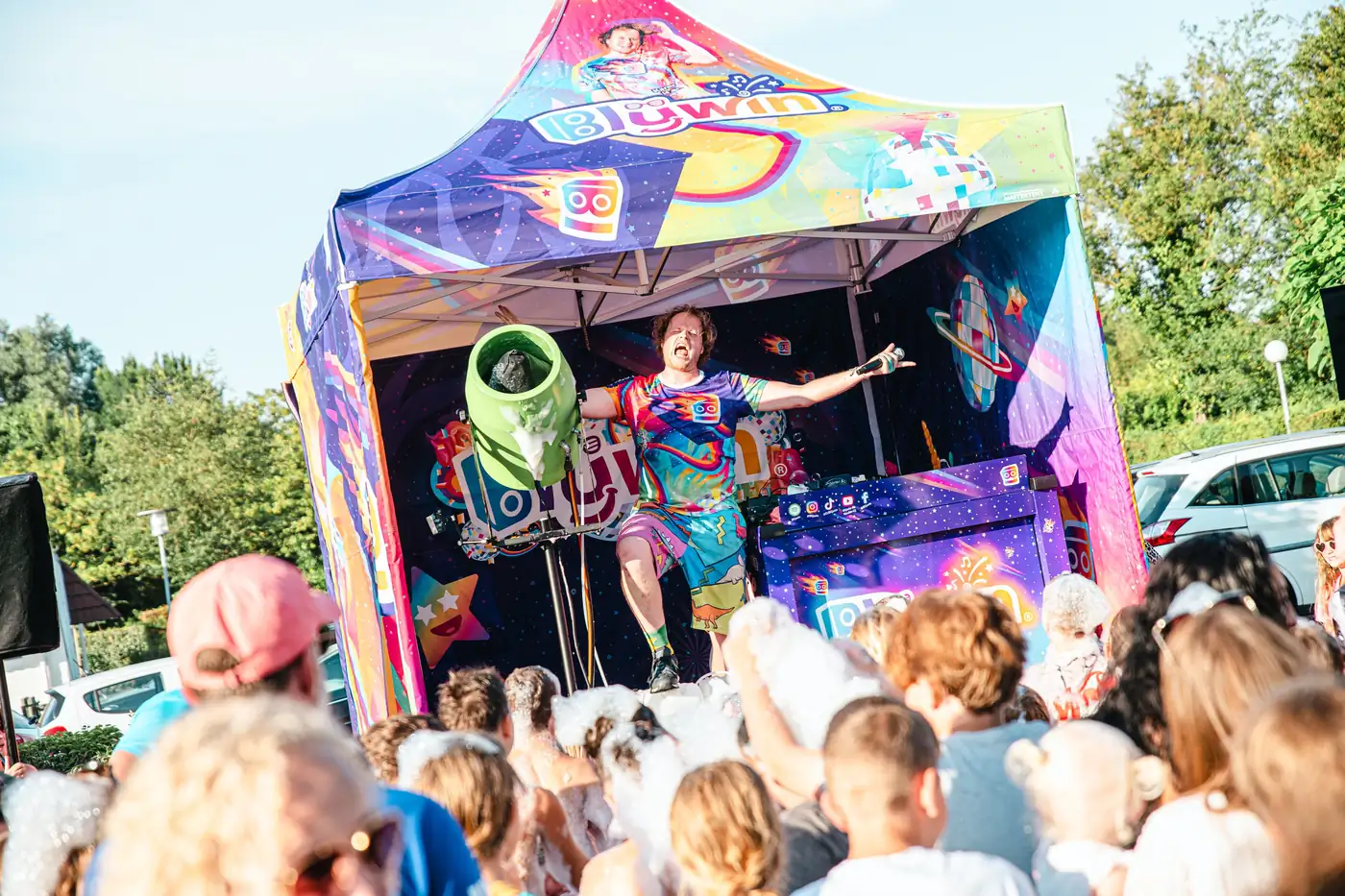 Blijwin® tussen spelende kinderen tijdens een outdoor regenboogschuimparty