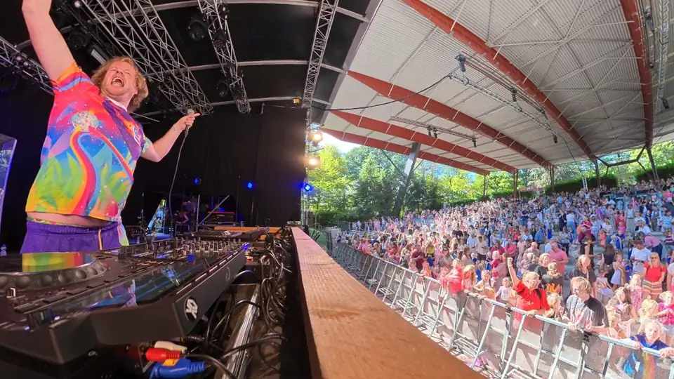 Kinder-DJ Blijwin® op een podium voor een volle openluchttheatertribune