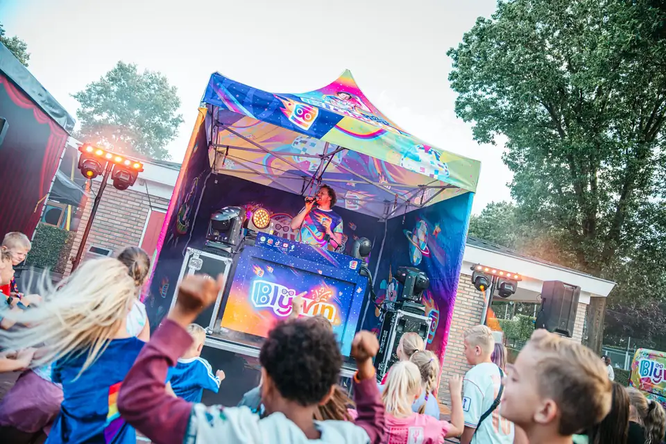 Kinderen dansen bij de DJ-booth tijdens een outdoor kinderdisco