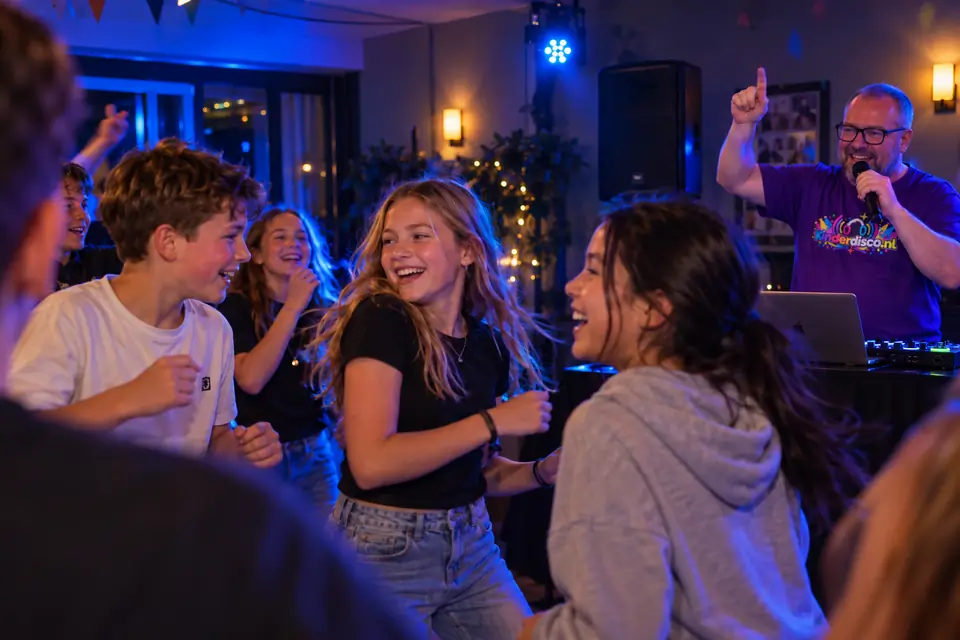 Groep 8-leerlingen dansen met DJ Martin in een buurthuis